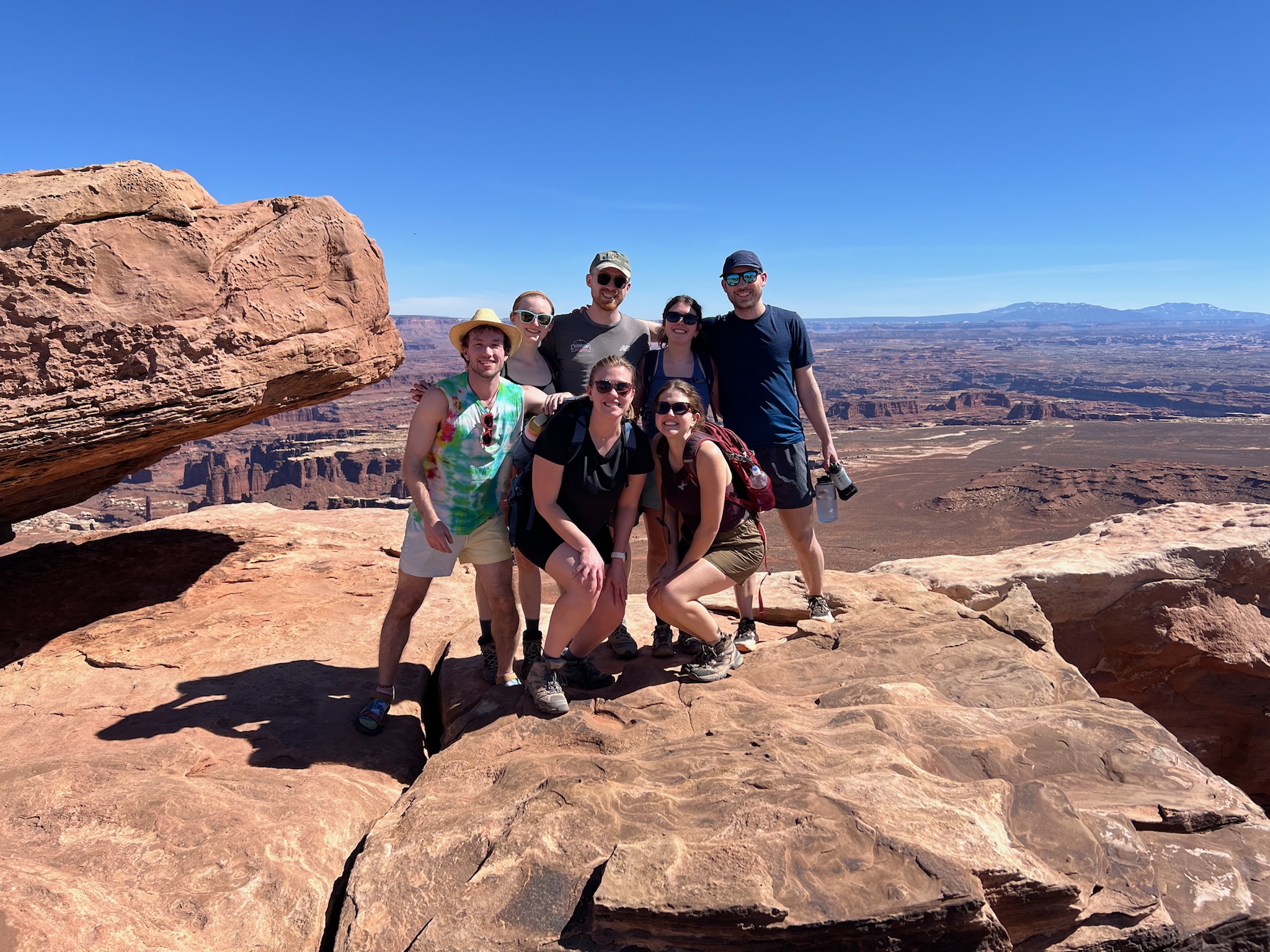 a group of friends posing at the lookout at Grand View Point in Canyonlands